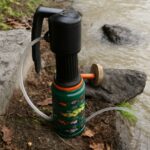 A portable water filter used in a hiking setting